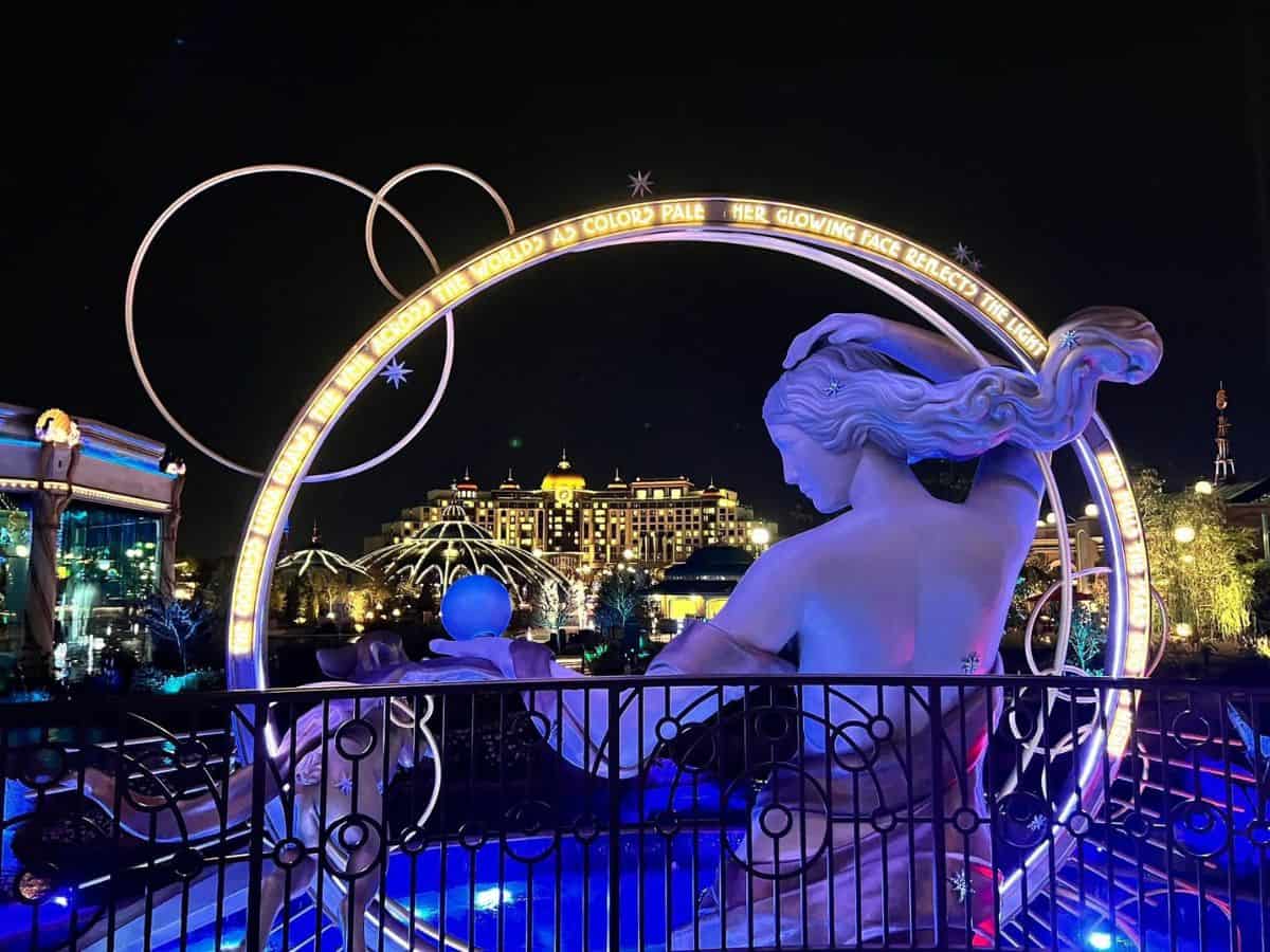 The Universal Grand Helios Hotel shows in the background at night through a hoop around Luna, the goddess of the moon.