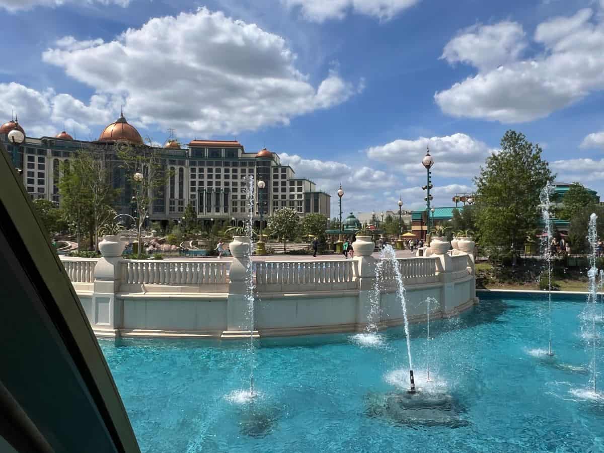 Fountains spray in the foreground and the Universal Helios Grand Hotel sits in the background.