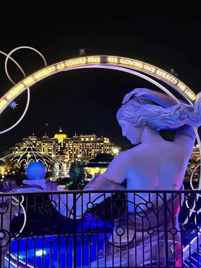 The Universal Grand Helios Hotel shows in the background at night through a hoop around Luna, the goddess of the moon.