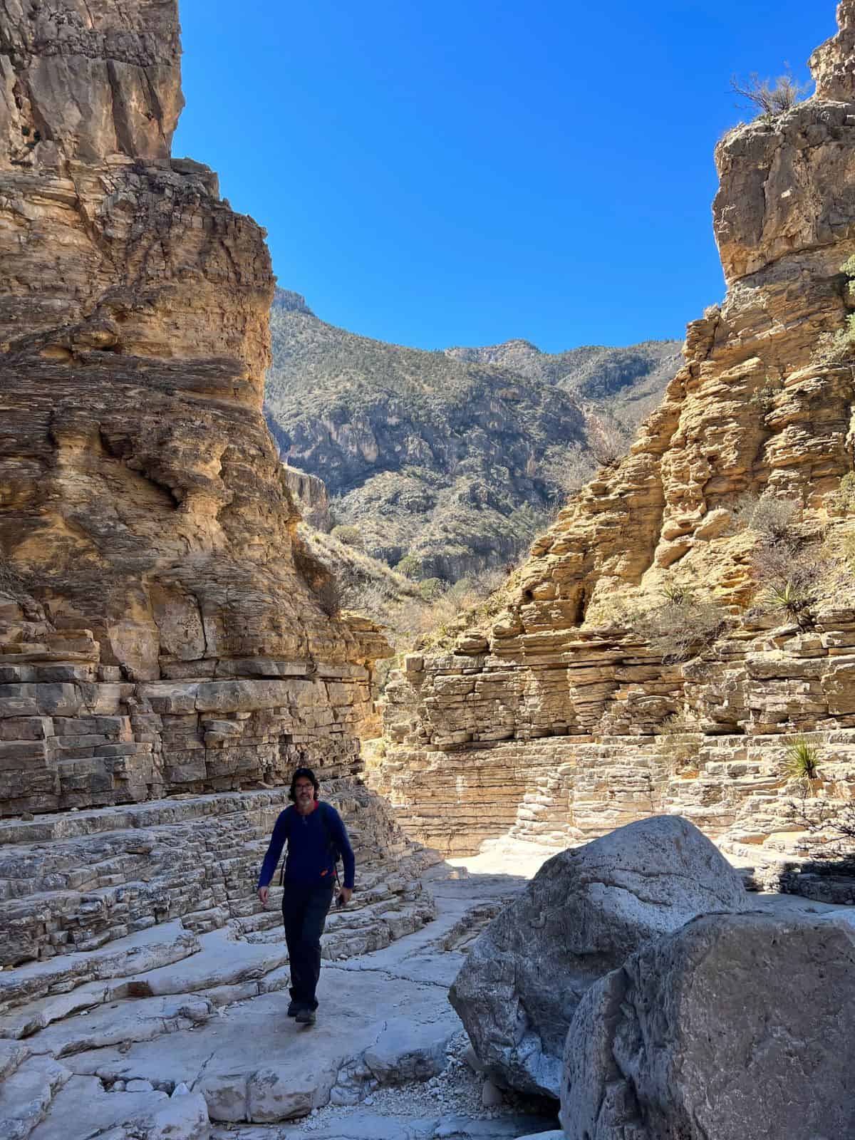A man hikes through a rocky canyon