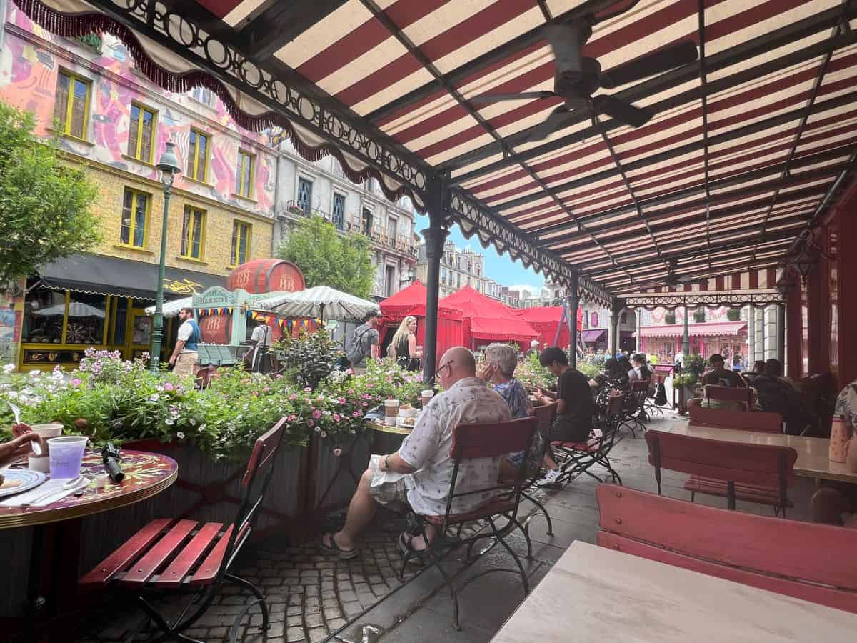 Guests relax under the awning in the outdoor seating section of Cafe L'air De La Sirene.
