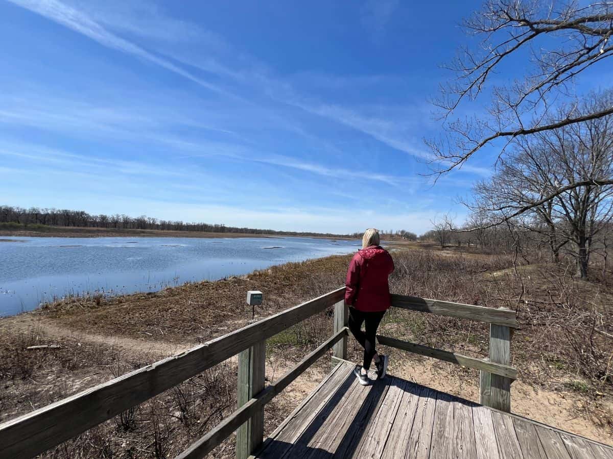 A woman stands on a platform looking for birds on Long Lake, near West Beach, Indiana Dunes National Park, IN.