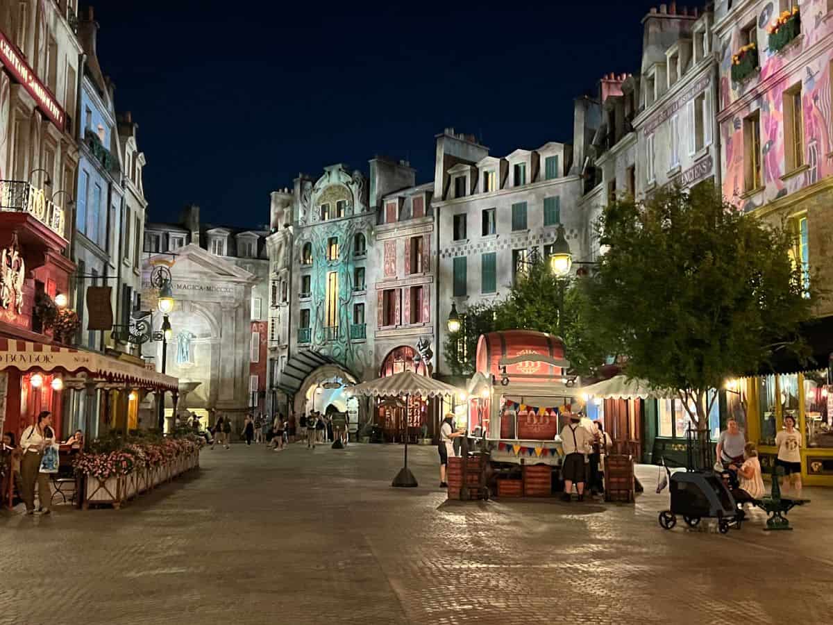Lights shine on the 1920s Paris buildings in the Epic Universe Harry Potter world.