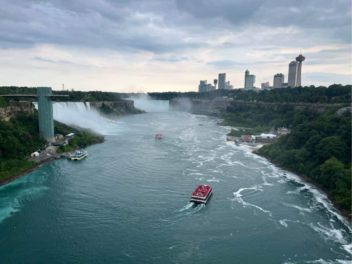 Boats full of guests navigate the waters along Niagara Falls between New York and Canada.