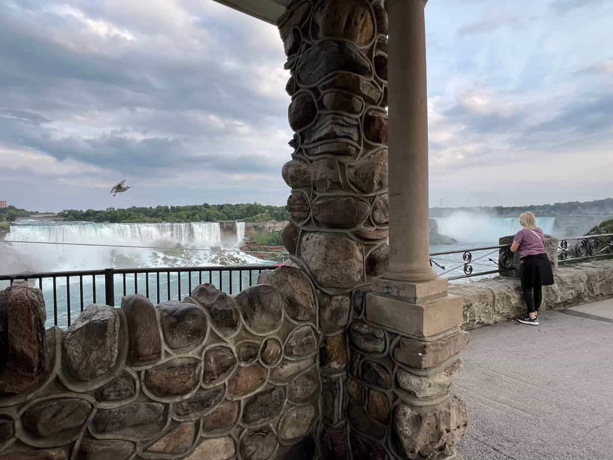 A woman looks at Niagara Falls from an overlook.