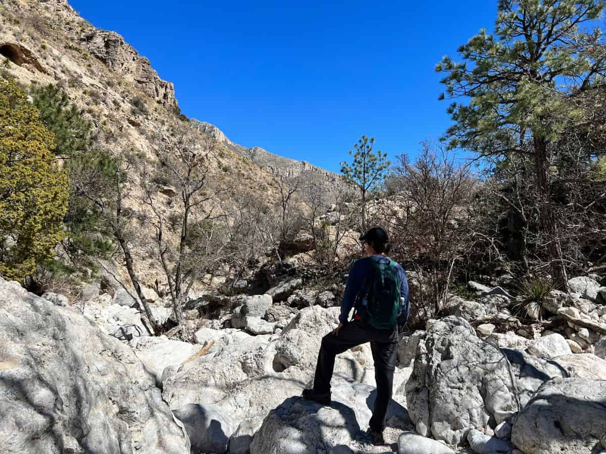 A man hikes up a rocky wash on Devil's Hall Trail, Guadalupe Mountains National Park, Texas.