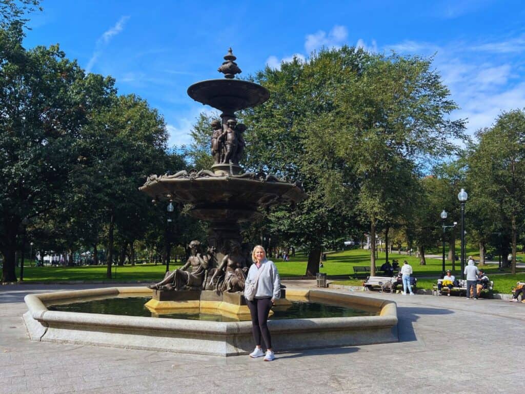 A woman poses for a picture in front of Brewer Fountain in Boston Common along the Freedom Trail