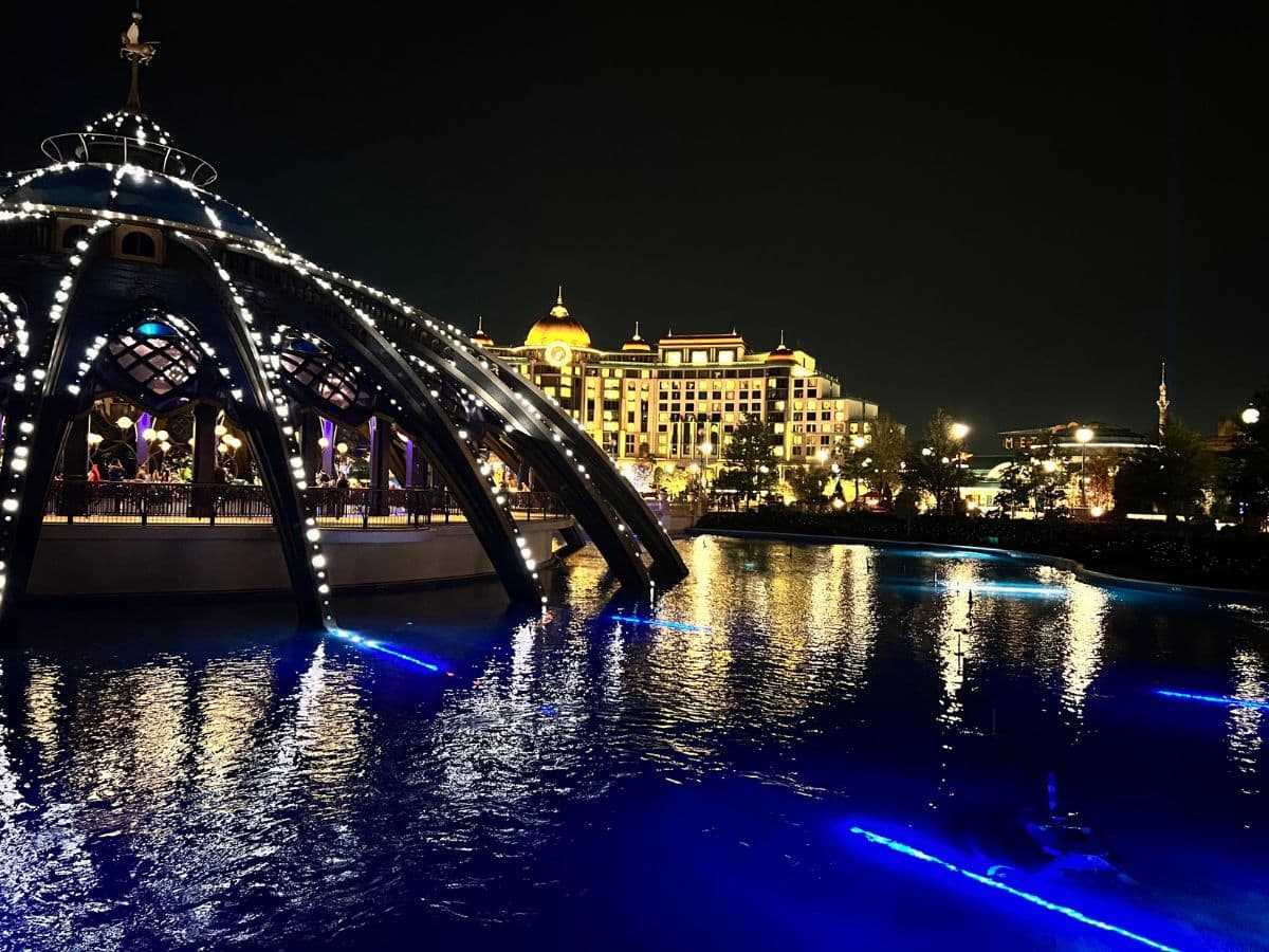 Universal Helios Grand Hotel is illuminated in the background from across a large fountain in Celestial Park