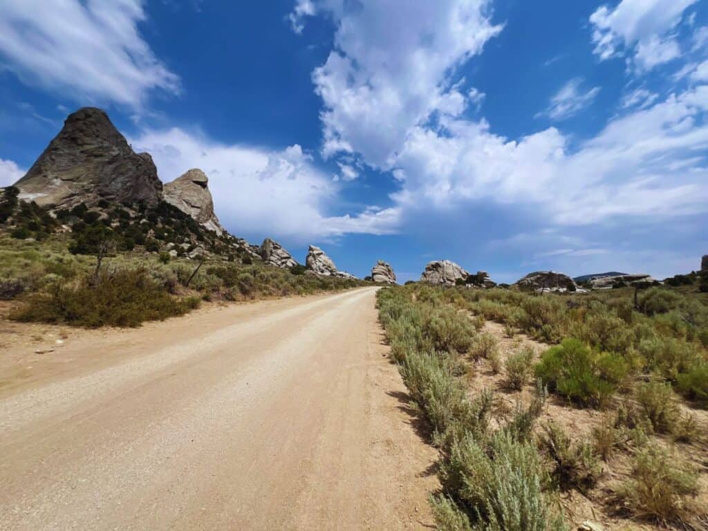 A dirt road is lined by granite spires and monoliths - an auto tour allows visitors to experience the rugged and beautiful City of Rocks Idaho