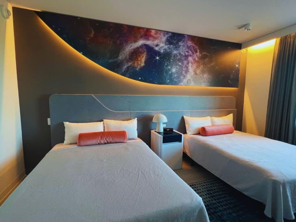 A hotel room wall displays an image of the Milky Way