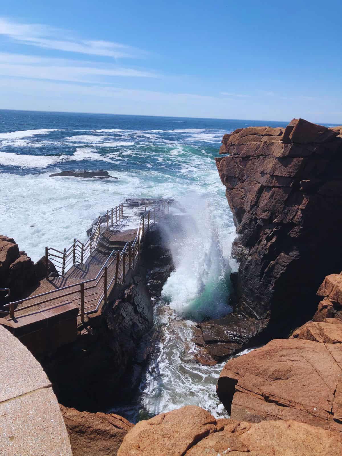 A staircase leads down to Thunder Hole where waves crash into an inlet and cause a loud booming sound