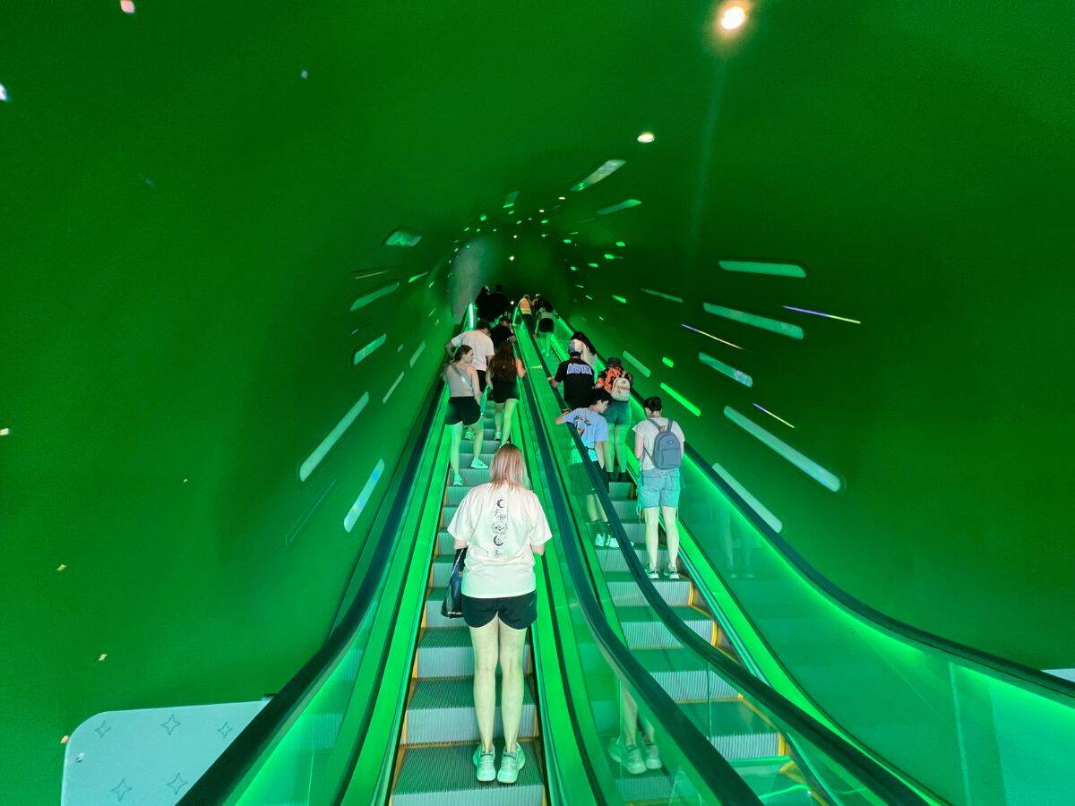Super Nintendo World Epic Universe guests ride the escalator, which simulates a green warp pipe
