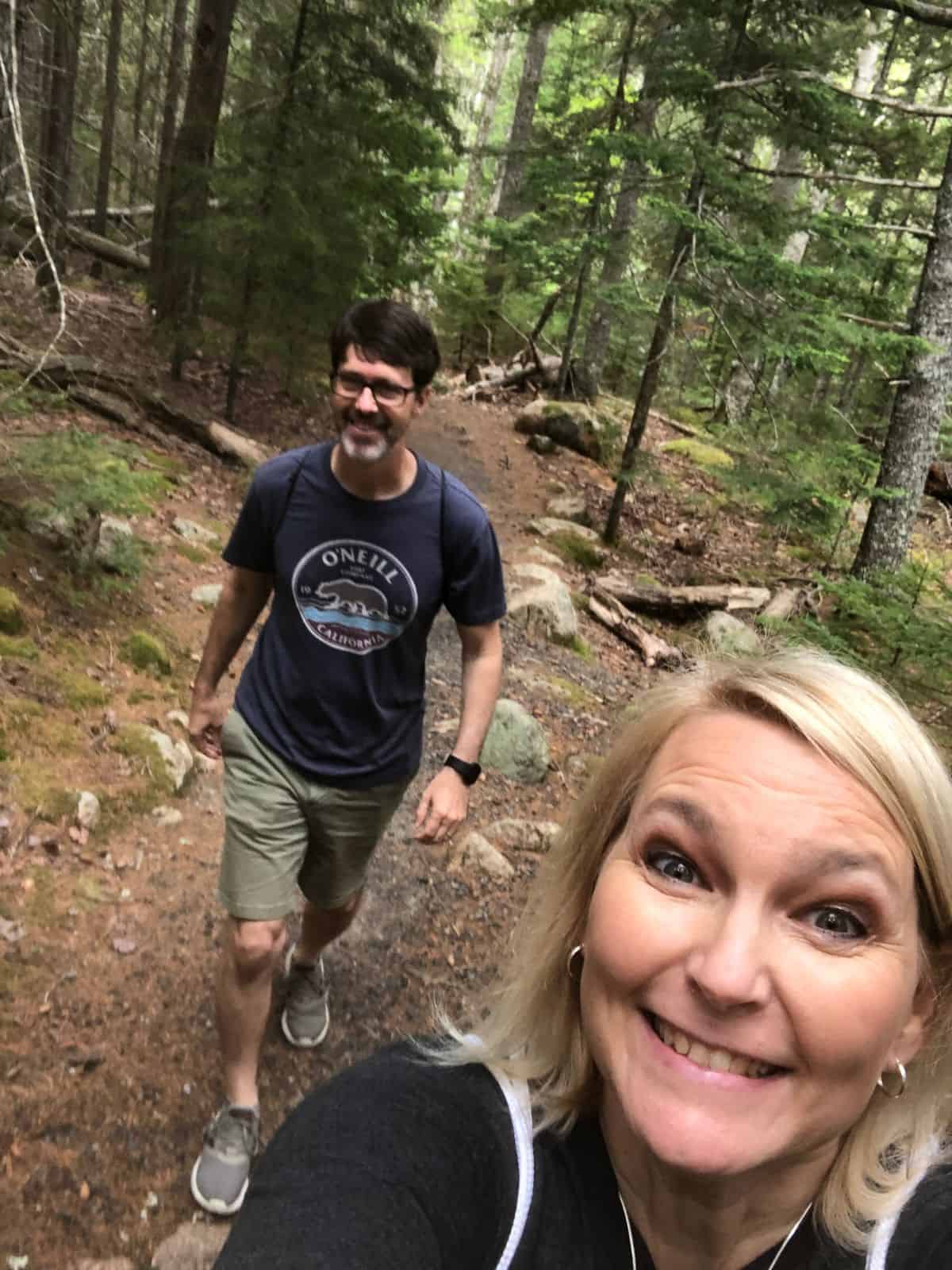 A man and a woman take a selfie while hiking in Acadia National Park, Maine