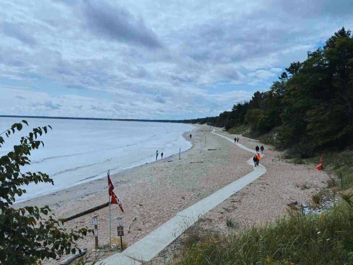 People walk a trail that skirts along Lake Michigan in Whitefish Dunes State Park, WI - a hidden gem state park in the USA.