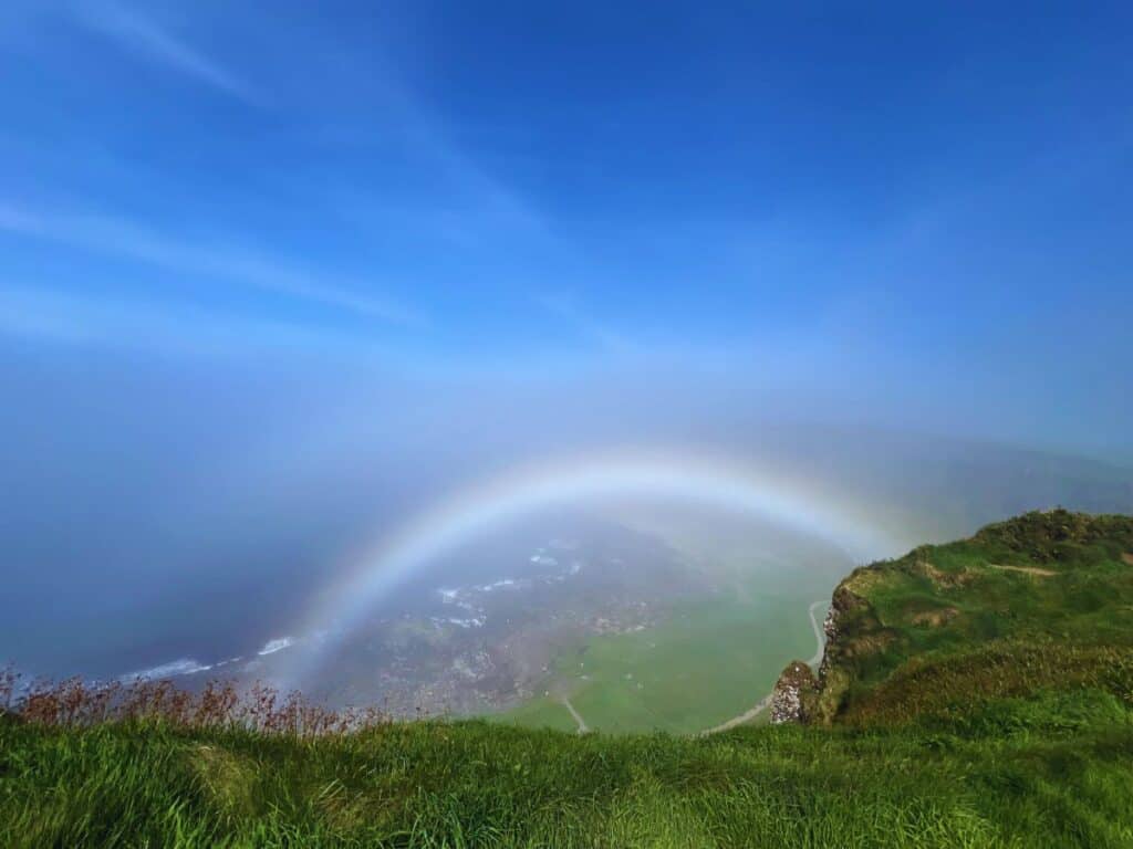A white rainbow forms in the mist at Giant's Causeway, Northern Ireland