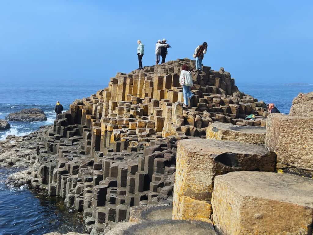 Tourists climb and take pictures at Giant's Causeway, Northern Ireland
