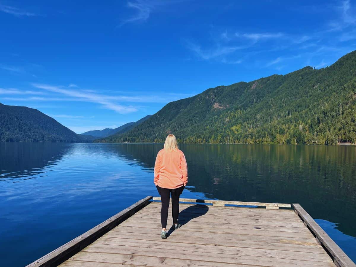 A woman walks to the end of a dock at Lake Crescent, Olympic National Park, WA