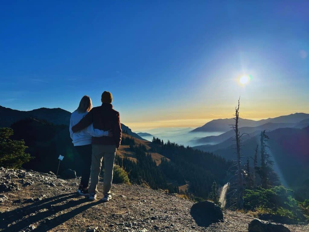 A man and woman look at the horizon from Sunrise Point, Olympic National Park, WA