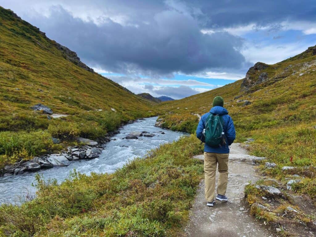A man hikes along the Savage River in Denali National Park and Preserve, Alaska