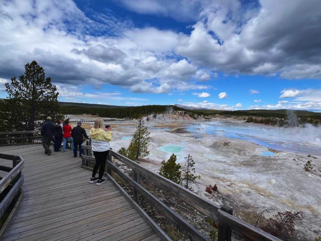 Visitors walk through Yellowstoneโs geothermal basin during the 2025 government shutdown, highlighting the parkโs resilience and continued accessibility.