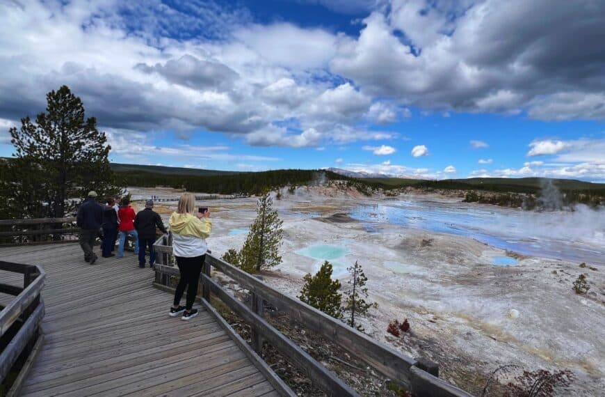 Visitors walk through Yellowstone’s geothermal basin during the 2025 government shutdown, highlighting the park’s resilience and continued accessibility.