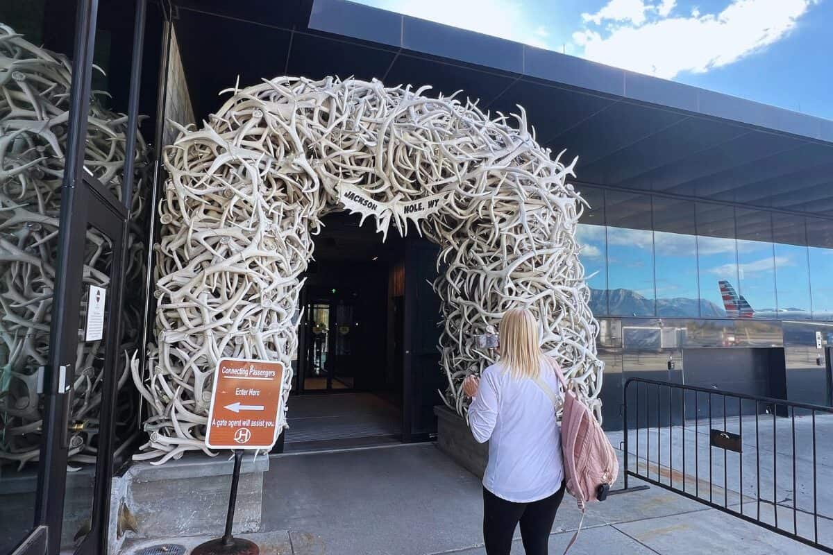A woman walks toward an antler arch at the doorway into Jackson Hole Airport, WY.