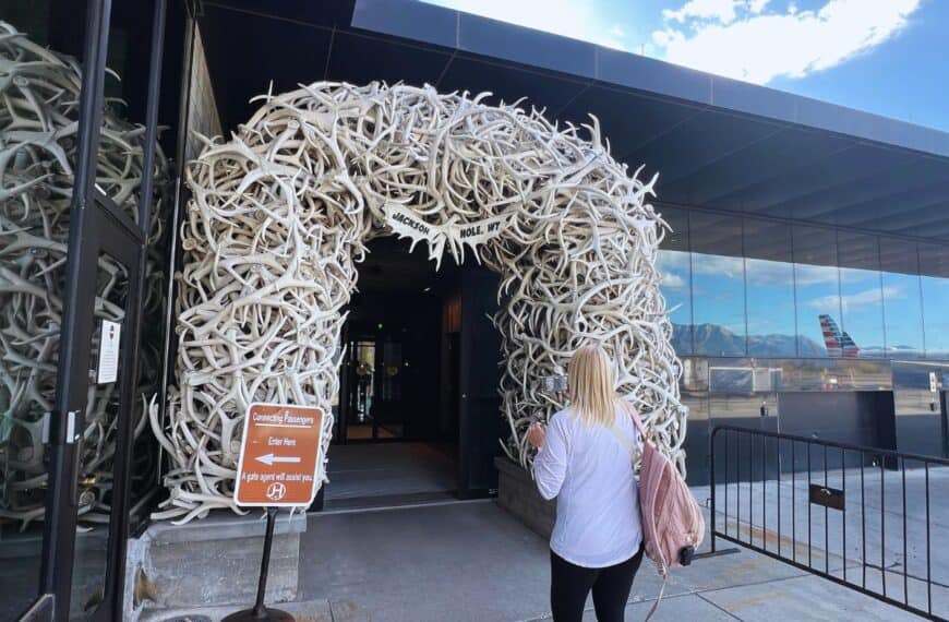 A woman walks toward an antler arch at the doorway into Jackson Hole Airport, WY.