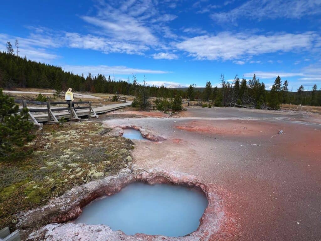 A woman walks a boardwalk trail at Artists' Paintpots, Yellowstone National Park, Wyoming.