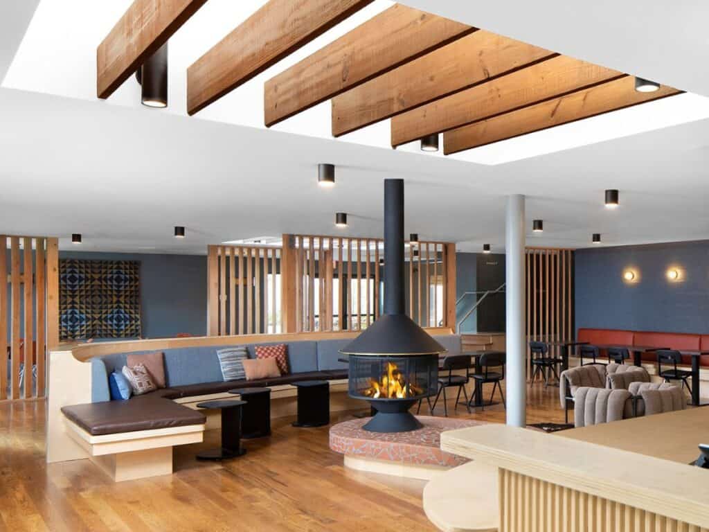 Comfy seats surround a cozy fire in the Rhodes Motor Lodge lobby.