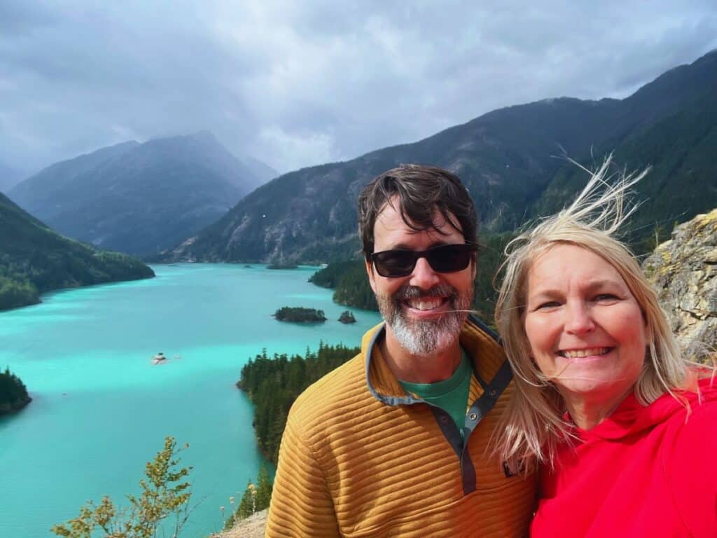 A man and woman pose for a picture above Diablo Lake, North Cascades National Park, WA.