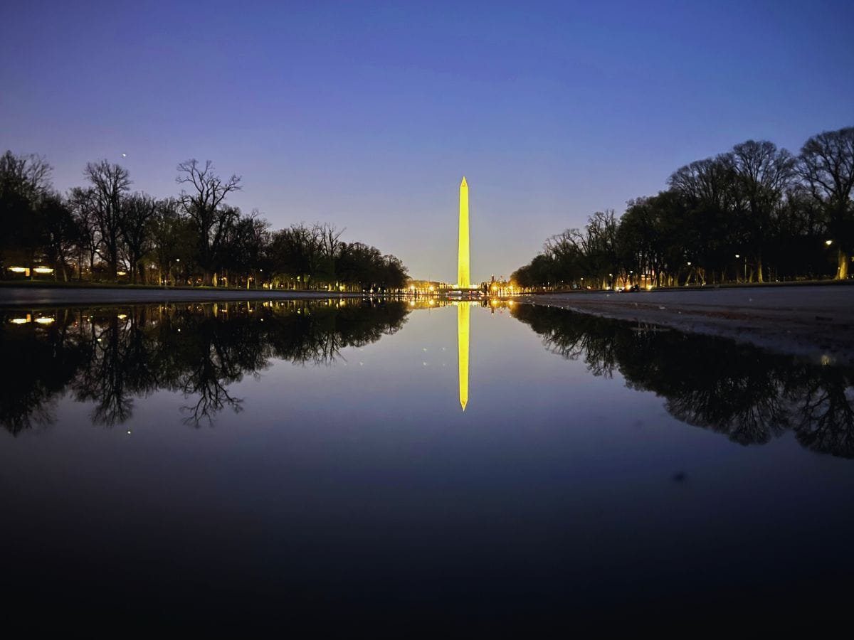 The Washington Monument reflects in the Lincoln Memorial Reflecting Pool at dusk