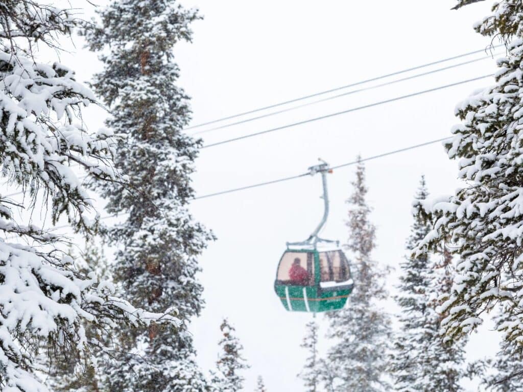 A gondola takes passengers across a mountain in winter