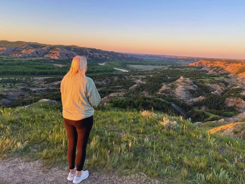 A woman enjoys a sweeping view of the North Dakota Badlands in Theodore Roosevelt National Park.