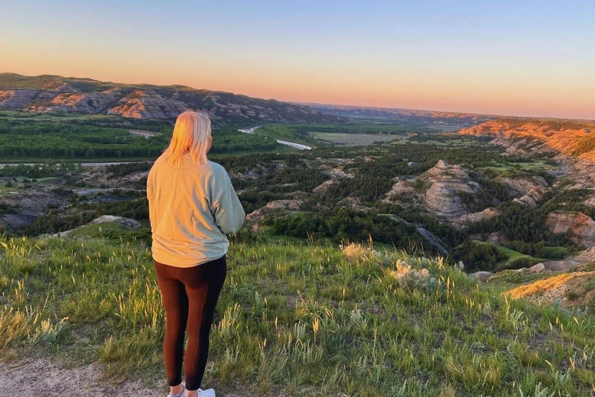 A woman enjoys a sweeping view of the North Dakota Badlands in Theodore Roosevelt National Park.