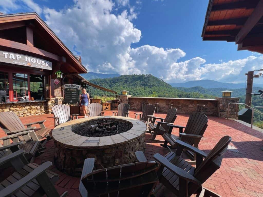 A woman walk toward a fire pit surrounded by chairs in the Smokies.