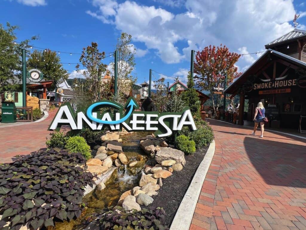 A woman walks past the Anakeesta sign and into the heart of the Smoky Mountain adventure park.